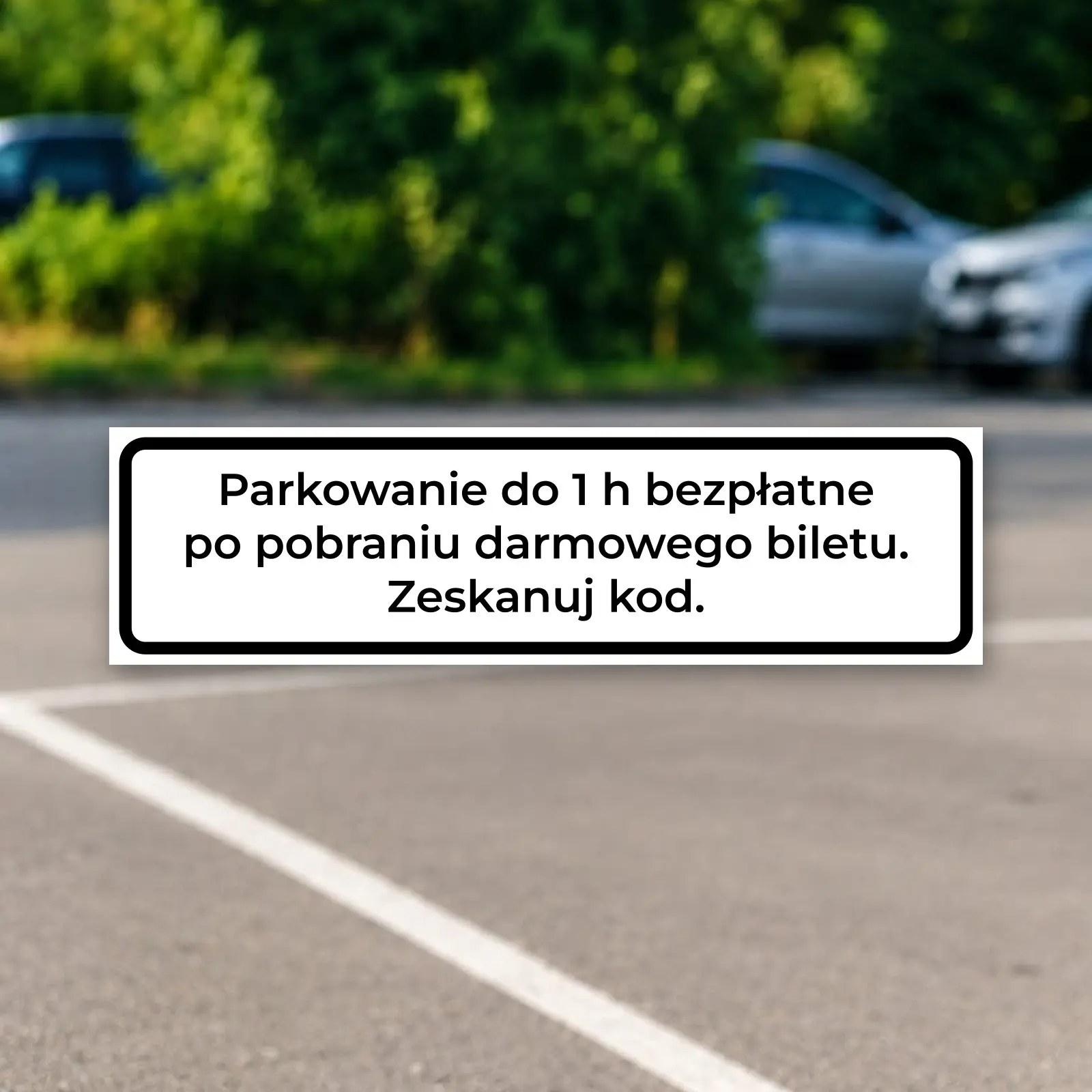 Tabliczka „Parkowanie do 1 h bezpłatne po pobraniu darmowego biletu. Zeskanuj kod.” na parkingu